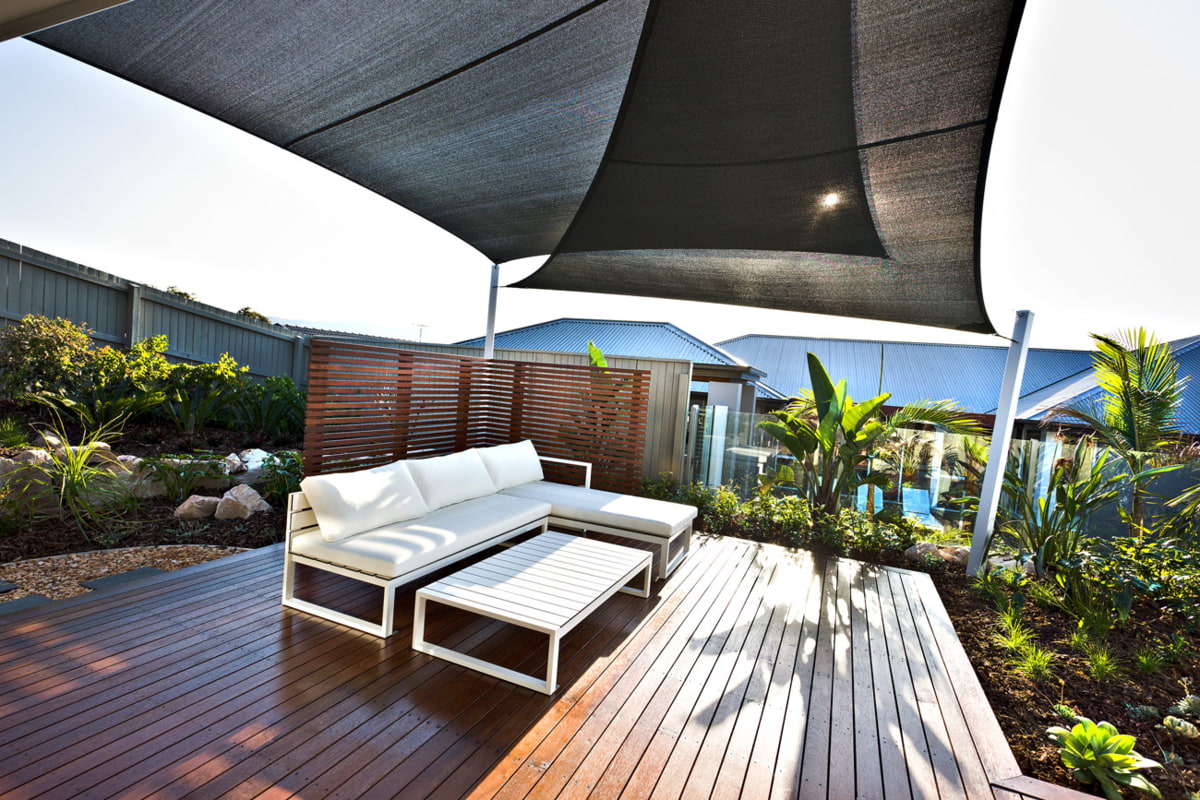 Terrasse mit Sonnensegel Terrasse mit Sonnensegel, Sitzmöglichkeiten und rundherum grüne Pflanzen - Garten Hennerbichler